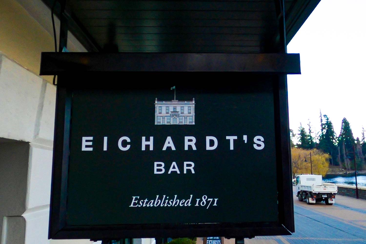 A hanging green shingle with white writing say Eichardt's Bar